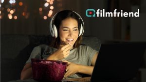 Frau mit Kopfhörer und Popcorn schaut Film